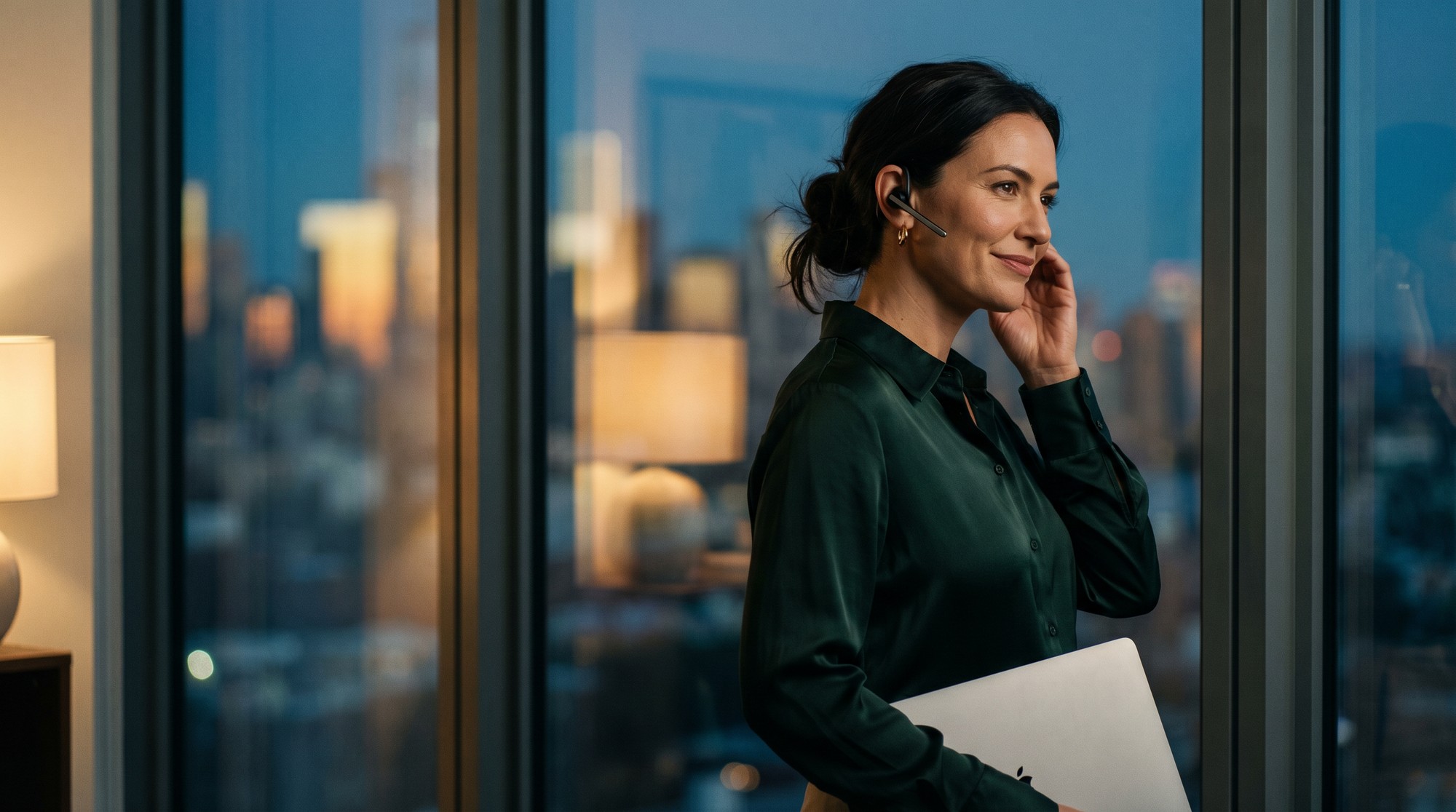 A Logixx customer overseeing her contact center from a city-view office at dusk